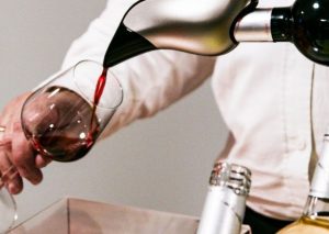 homme utilise aérateur de vin pour verser bouteille de rouge